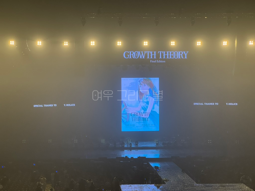 체조경기장 내부에서 무대를 확대하여 촬영한 장면. 중간에는 GROWTH THEORY Final Edition 앵콜 콘서트 포스터가 띄워져 있고 양 옆으로는 'Special Thanks to Y.HOLICS' 문구가 띄워져 있다.