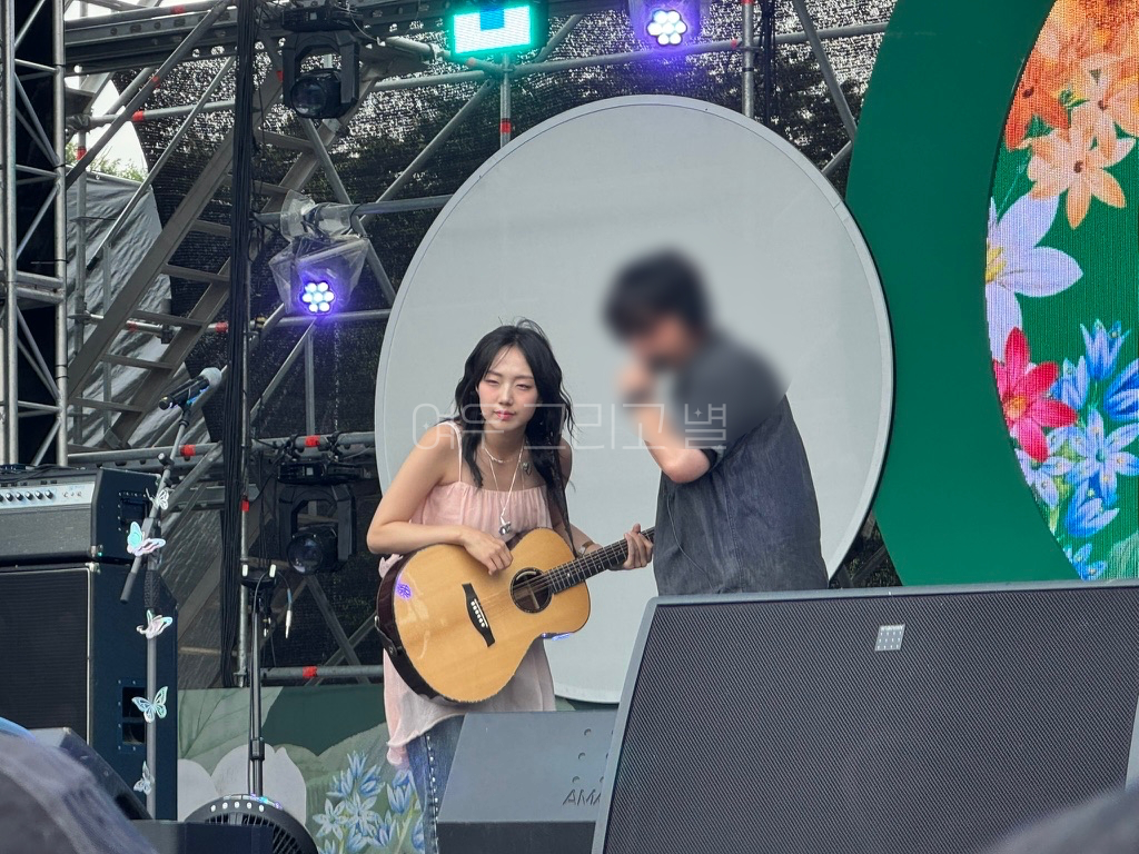 통기타를 매고 있는 유다빈과 스탭이 대화를 나누는 장면이다.